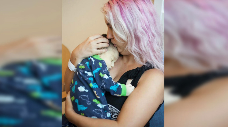 mom with pink hair cradling baby