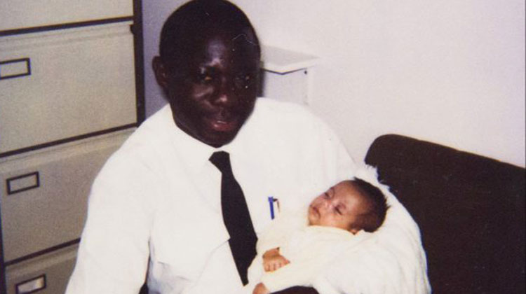 man holds little baby in old photograph