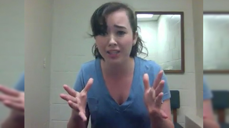 girl in blue singing with hands up