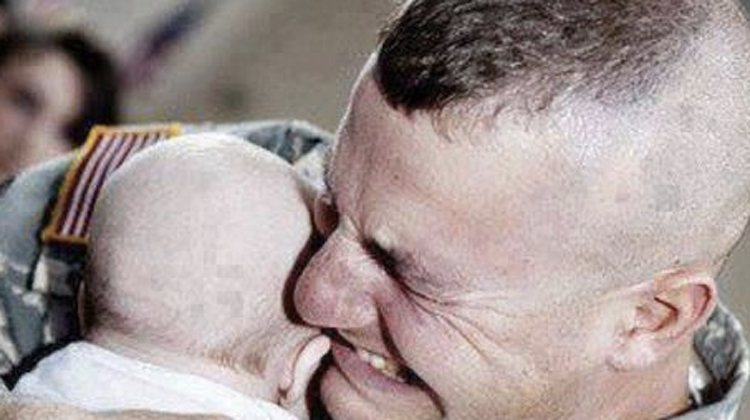 man cries holding newborn