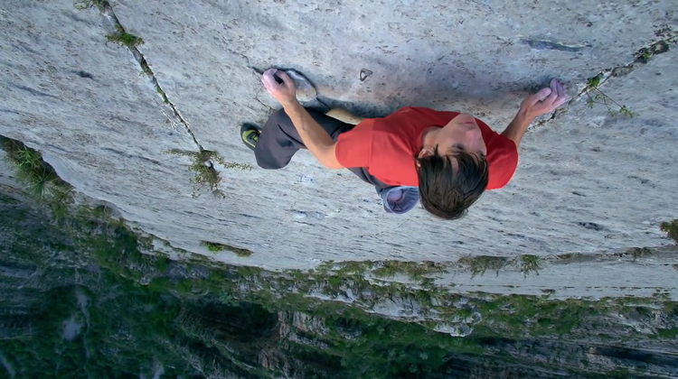 Man Climbing Up Rock Face Without Ropes