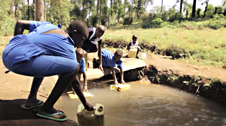 African boys and girls filling up water jugs from dirty source