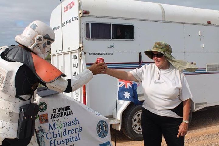 stranger giving drink to scott loxley while he storms through australia