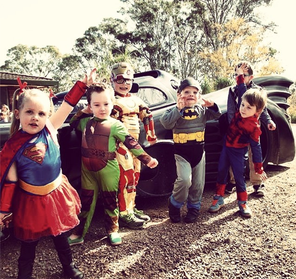 kids stand by the batmobile