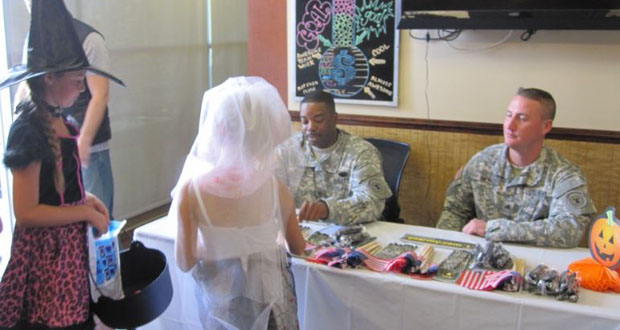 kids giving candy to soldiers