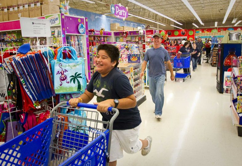 kid with shopping cart running 