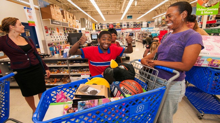 kid excited over shopping cart full of toys