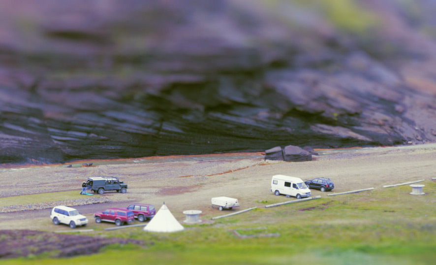 Tilt shift photography perspective of cars from a mountain