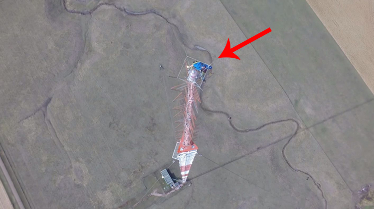 man at the top of a tv tower