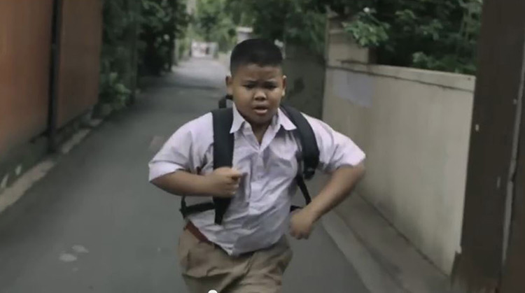 Little kid running to help his mother clean streets