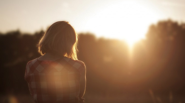 Image of girl pondering into the sunset