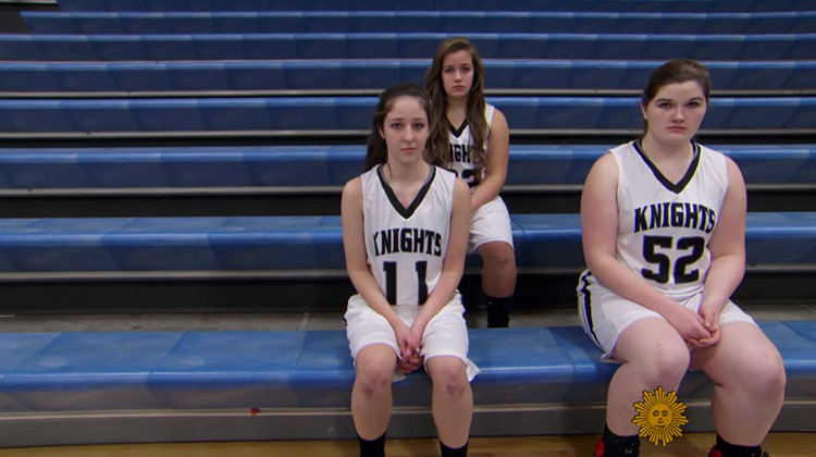 3 girl basketball players sitting in the stands