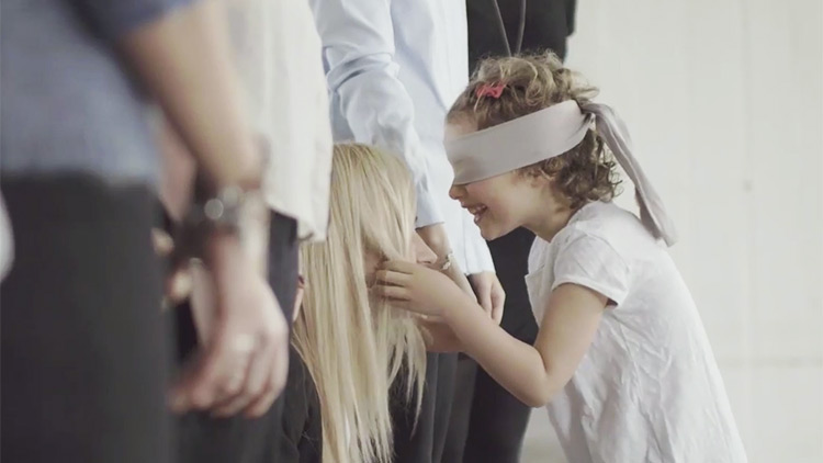 Little girl in blindfold searching for mom's face
