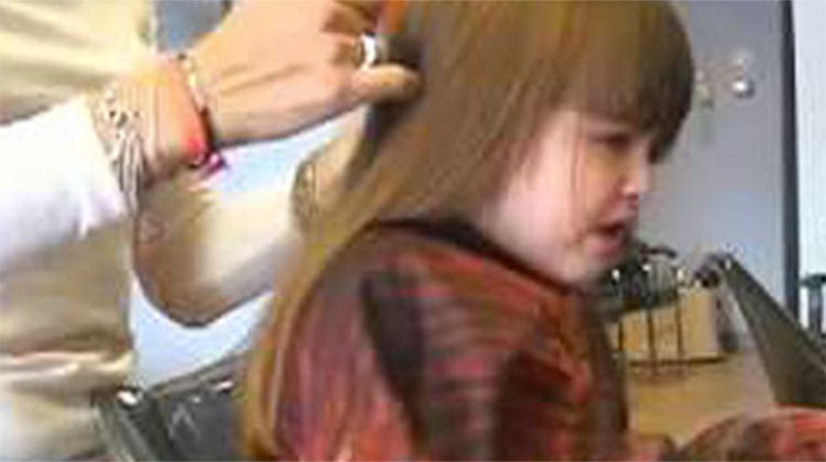 Girl crying while getting hair cut