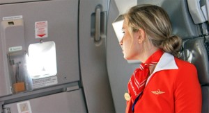 Flight attendant looking out plane window