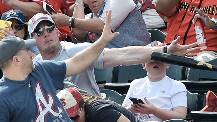 shaun cunningham protecting his son landon from getting hit by a baseball bat.