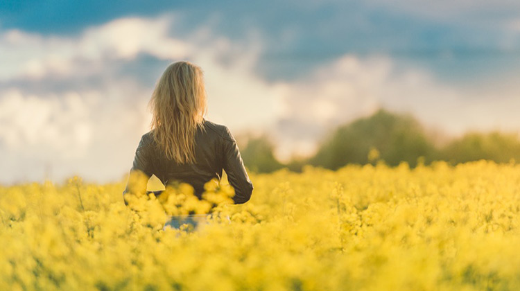 Girl in field of yellow flowers