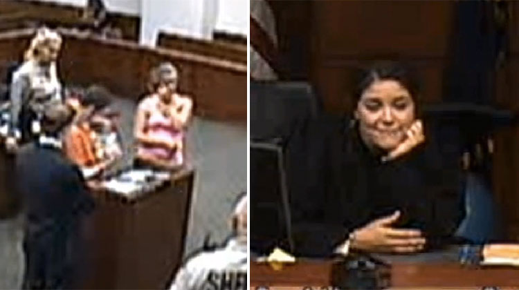 judge looks happily at inmate holding baby for first time