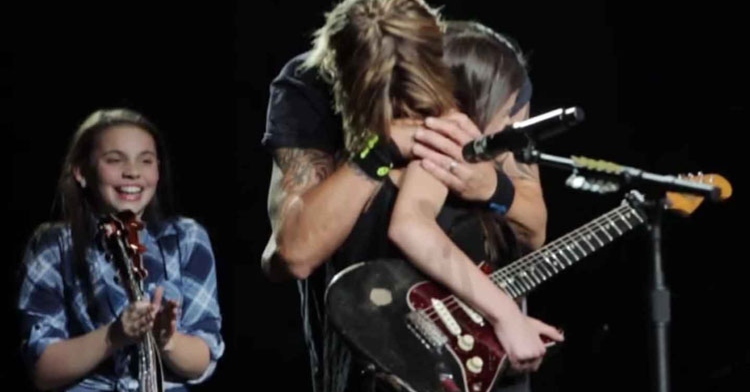 keith urban hugs fan holding guitar