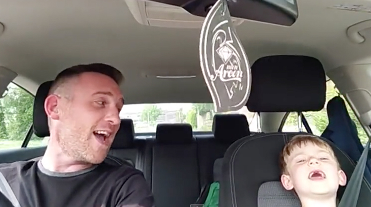 father and son sing in car