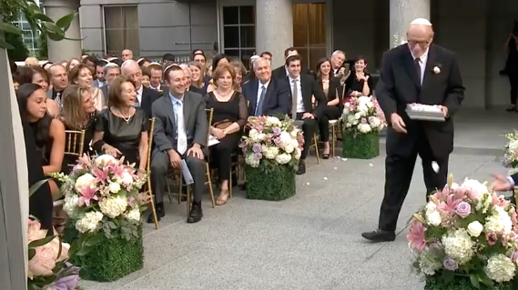 grandpa in suit throws flowers at wedding