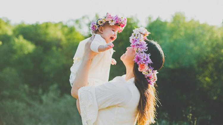 daughter held by mom with flower crowns