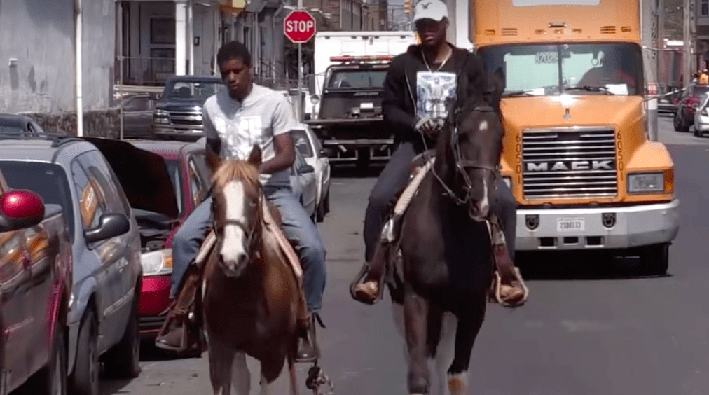 Boys riding horses in inner city