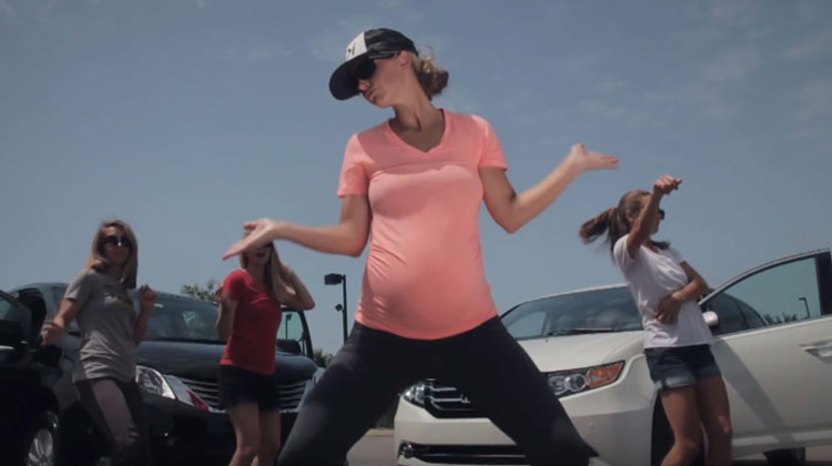 pregnant mom in pink with hat dancing in front of van