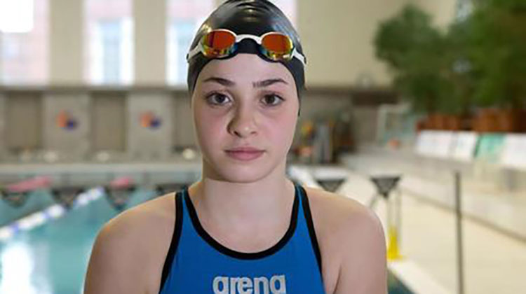 teen swimmer in suit with goggles on head