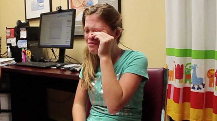 teen crying in teal shirt at doctors office