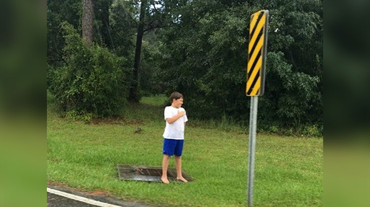 barefoot boy standing in rain at attention