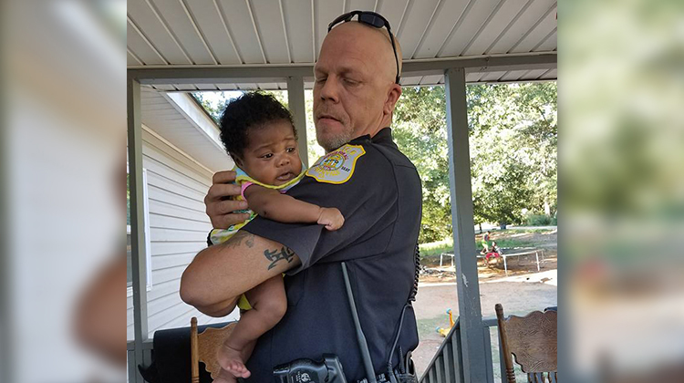 cop holding little infant girl