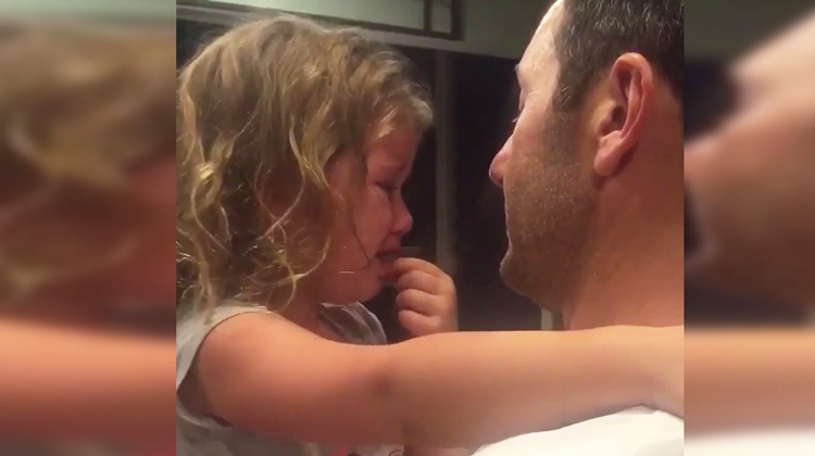 little girl sobbing and held by dad