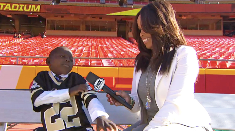 boy interviewed by reporter at stadium