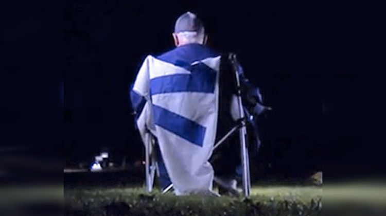 man in lawn chair in dark