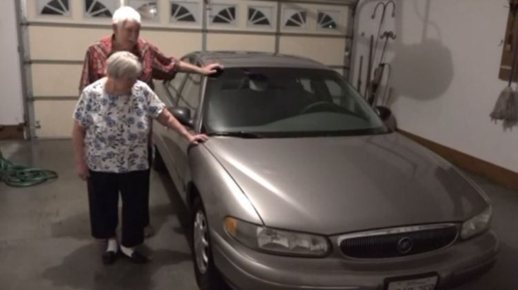 elderly couple by old buick in garage