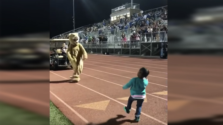 little girl dancing with mascot
