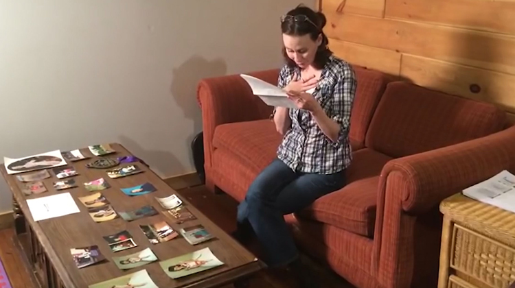 girl on couch reading letter surrounded by photos