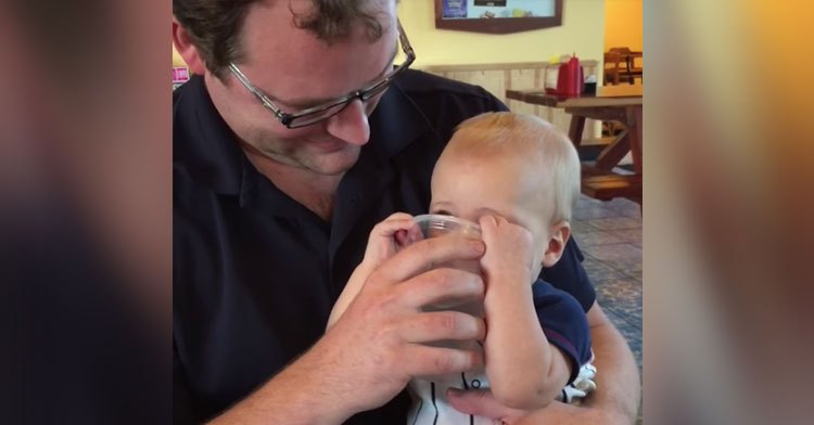 baby drinks water from cup