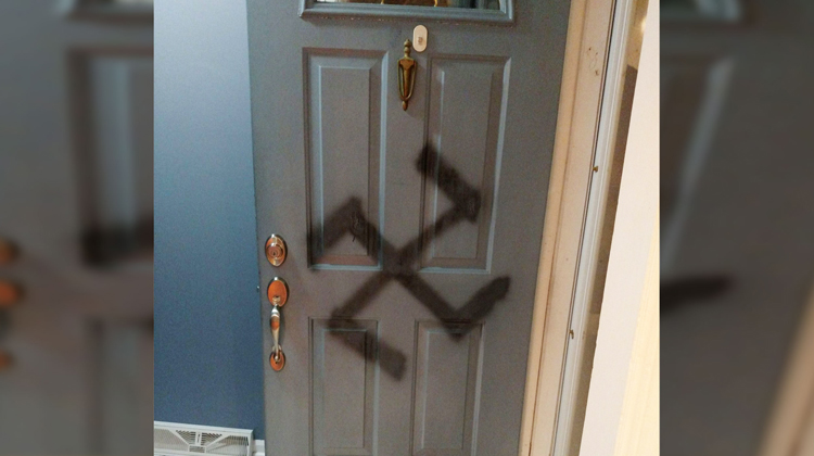 door with swastika spray painted in black