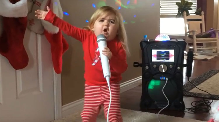 little girl in red pajamas singing karaoke