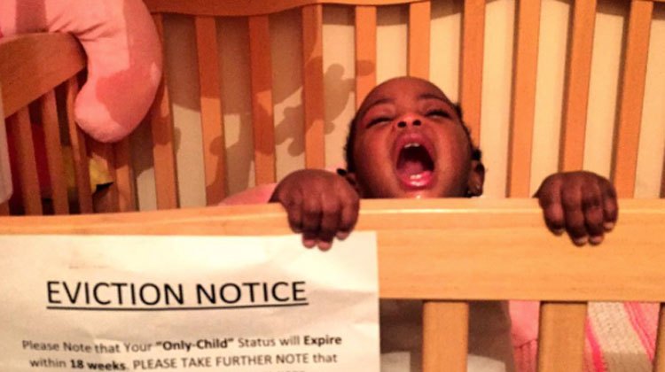 baby crying in crib with paper eviction notice