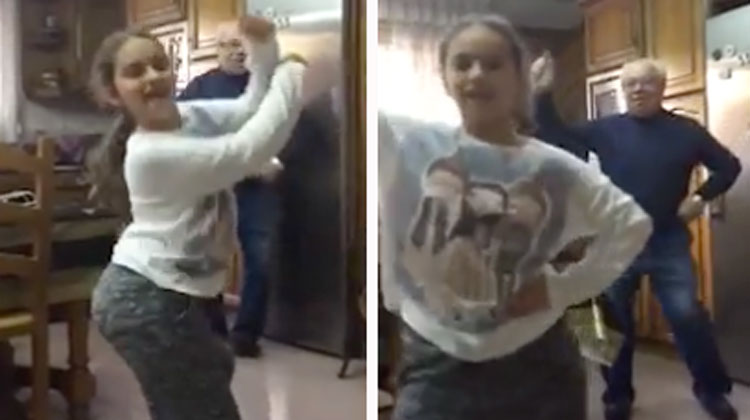 girl dancing with grandpa behind her in kitchen
