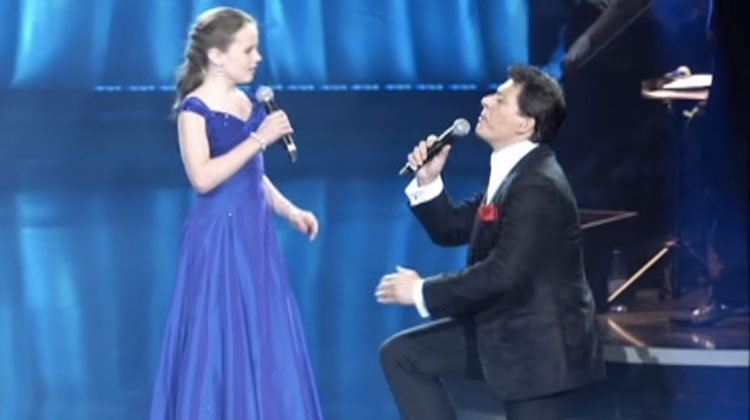 girl in blue dress sings with opera store