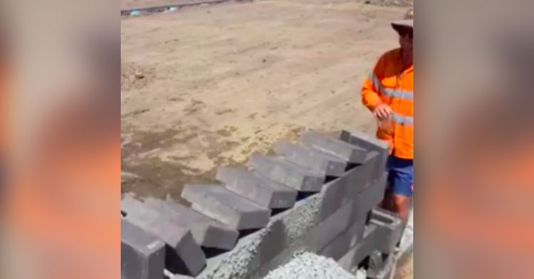 construction worker tips over bricks lined up