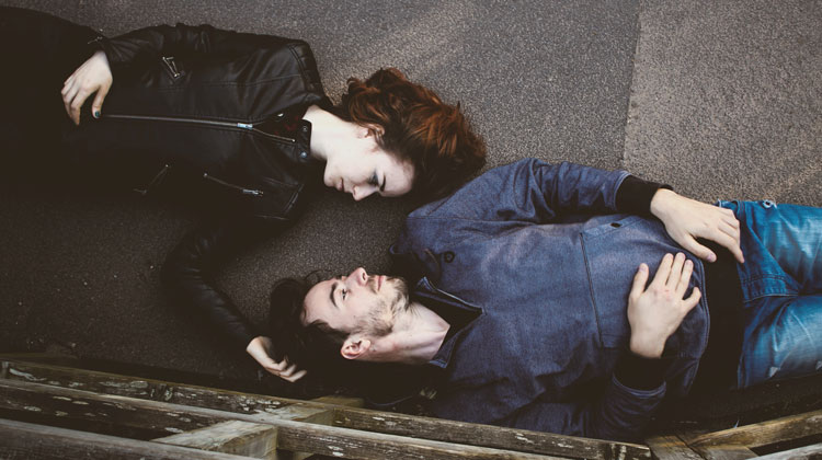 man and woman laying on ground