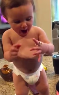 baby tries on mom's ring