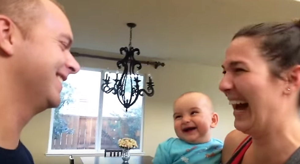mom dad and baby laughing