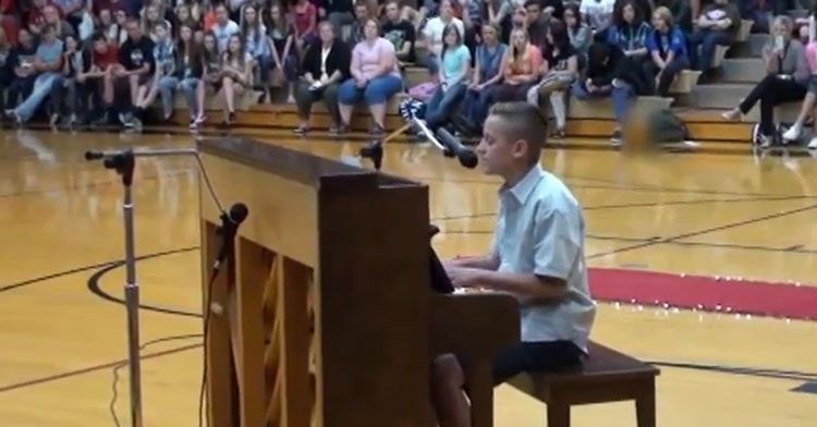 boy playing piano in school gym