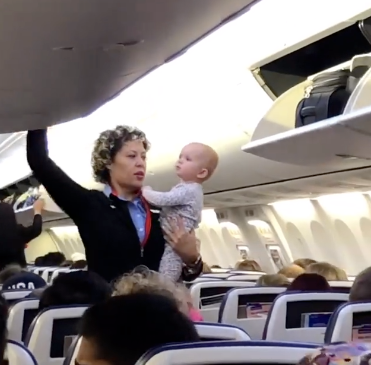 flight attendant holds baby